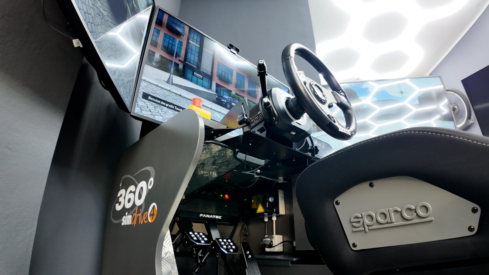 Fahrsimulator 360° simdrive mit Sportsitz und drei Bildschirmen